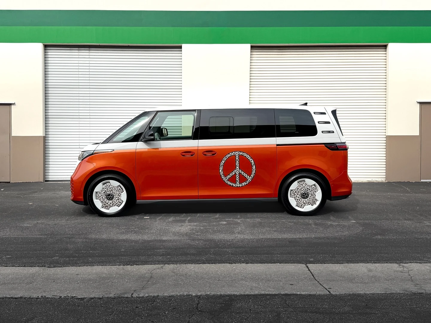 VW iD. Buzz custom orange and white wrap with peace sign graphics by Vaderwerks