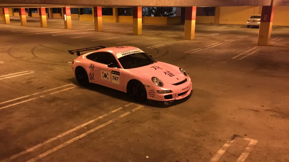 Pink Porsche 911 GT3 747 livery by Vaderwerks in a parking garage